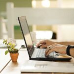 An image shows a man working online on a laptop