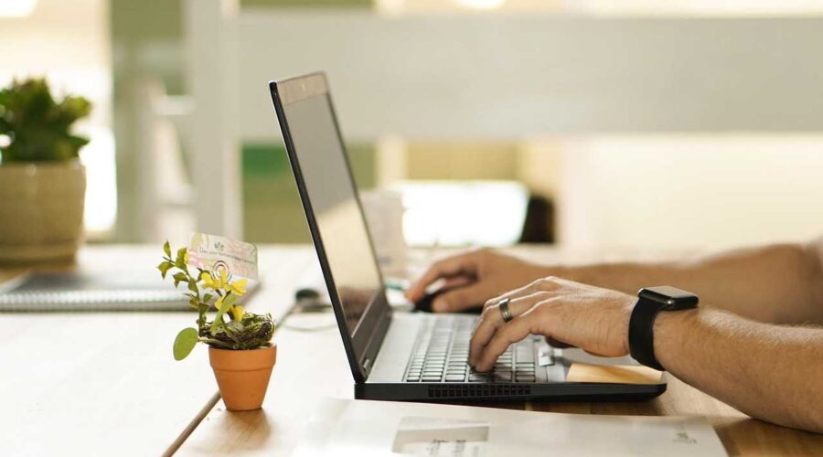 An image shows a man working online on a laptop