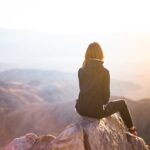 A Woman sitting on top of a hill