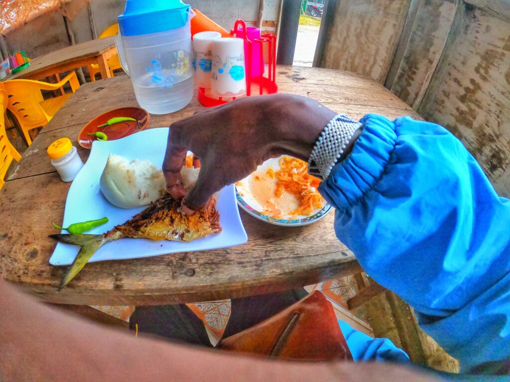 Eating ugali and fish a typical swahili dish in coast of Kenya 