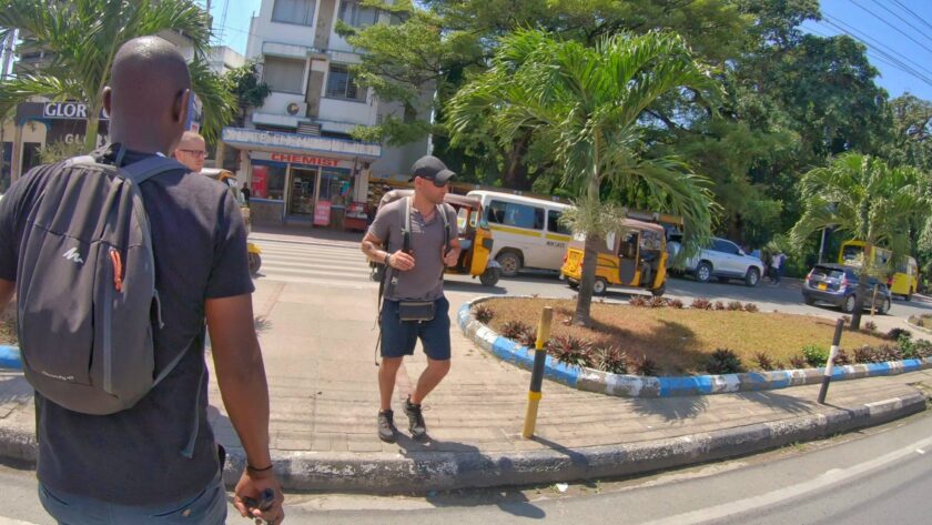 A tourist crossing a road along Moi Avenue close to tusk monuments in Mombasa