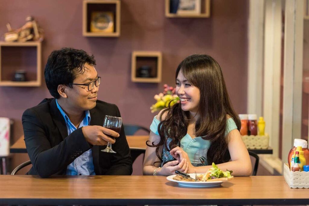 A man drinking while a woman eating in a house