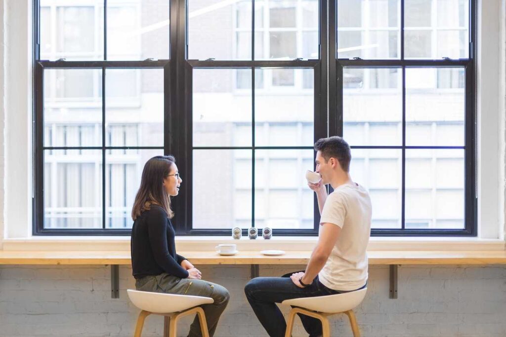 A man and a woman sitting drinking coffee 