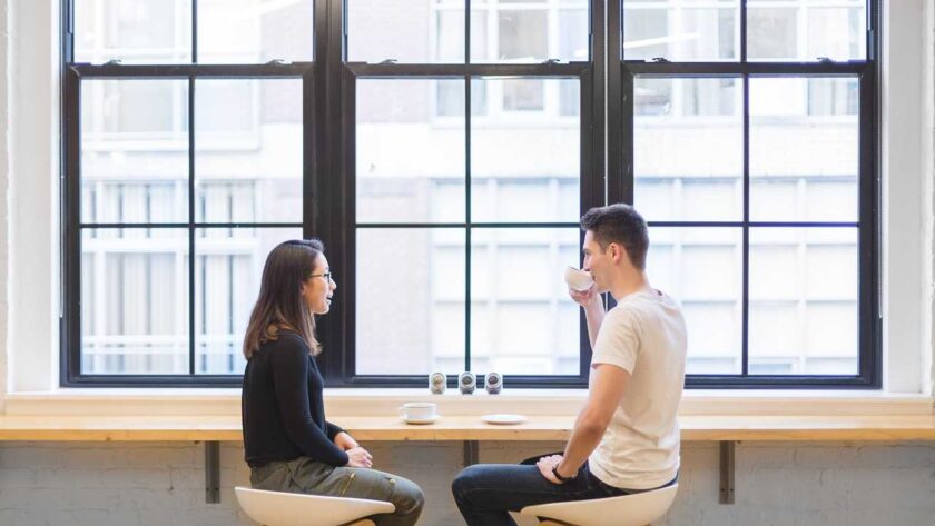 A man and a woman sitting drinking coffee