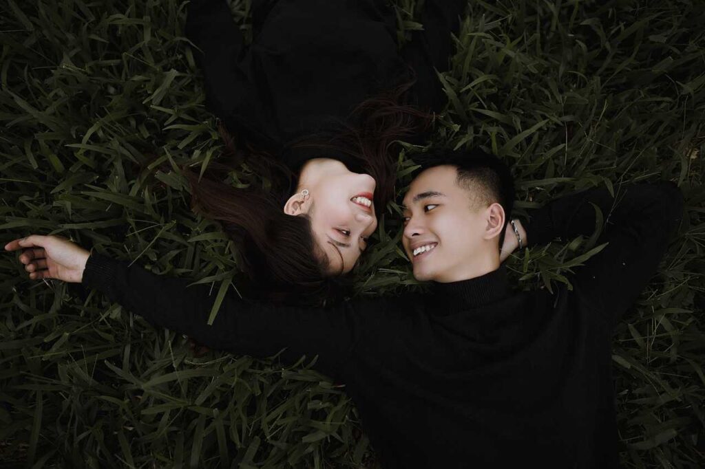 A man and a woman laying down looking at each other on opposite sides