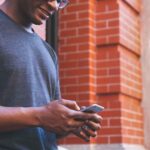 A man reading a text while smiling