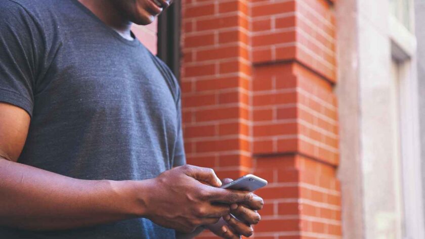 A man reading a text while smiling