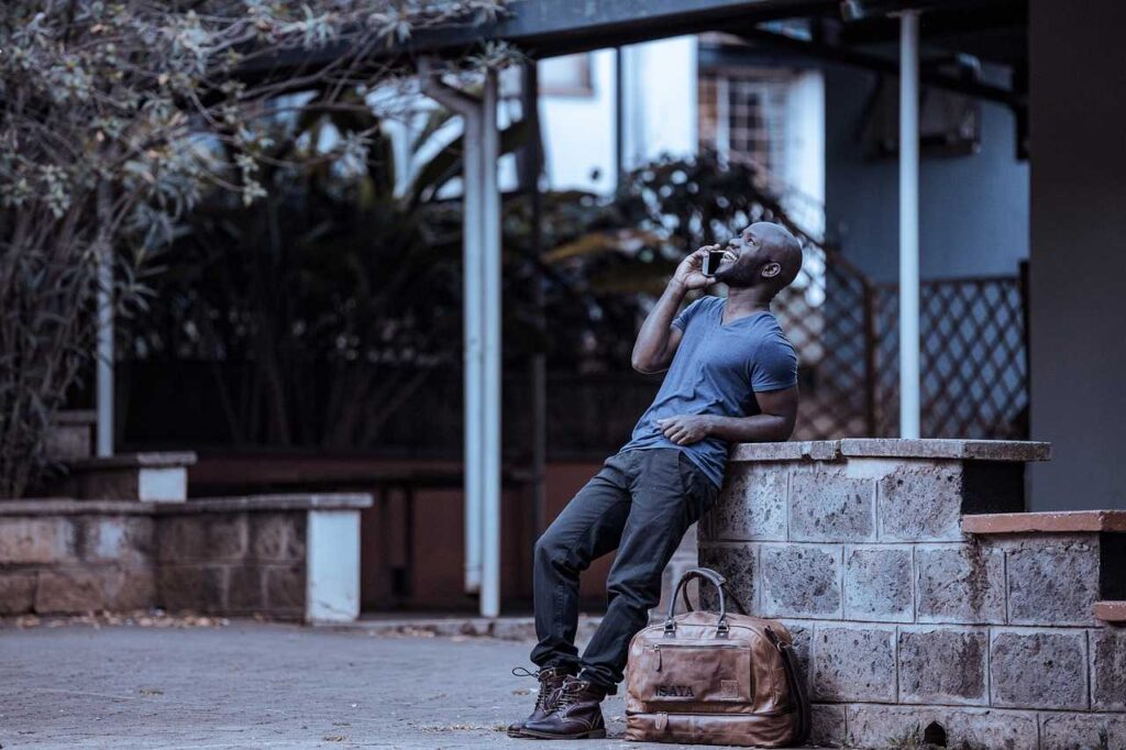 Man leaning on a wall making a call