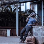 Man leaning on a wall making a call