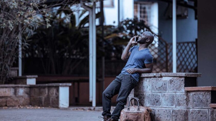 Man leaning on a wall making a call