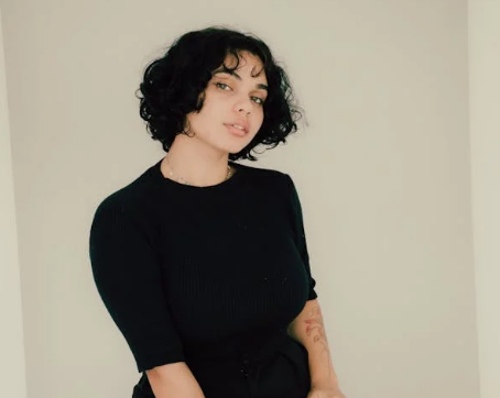 a woman with a short hairs and black T-shirt looking in front