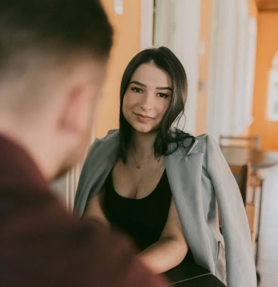 a man looking at a woman sitting in front of her