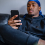 a man sitting on a sofa texting