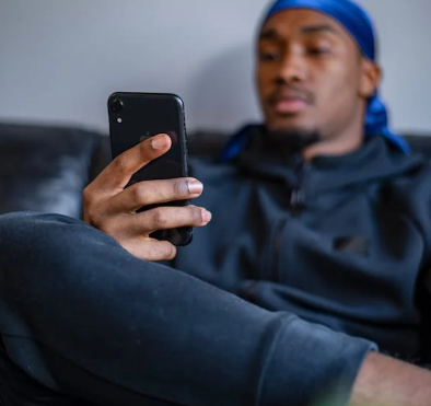 a man sitting on a sofa texting