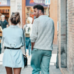 a man looking at a woman walking next to him