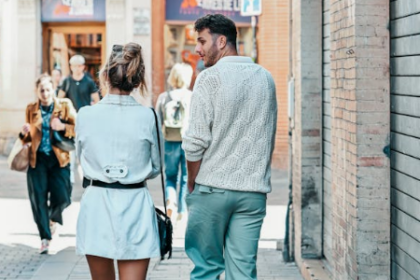 a man looking at a woman walking next to him