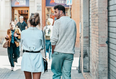 a man looking at a woman walking next to him