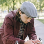 man reading a text while on a bycicle