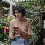 a woman holding her phone while seems confused