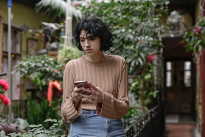 a woman holding her phone while seems confused