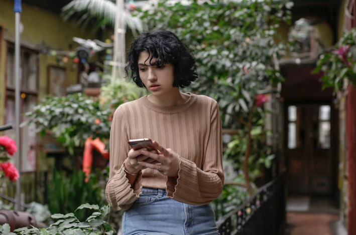 a woman holding her phone while seems confused