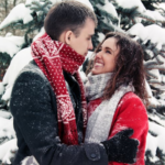 a man and a woman holding each other while it snows