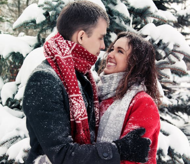 a man and a woman holding each other while it snows