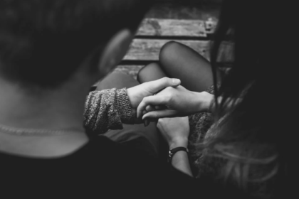 a man sitting next to a woman while holding her palm